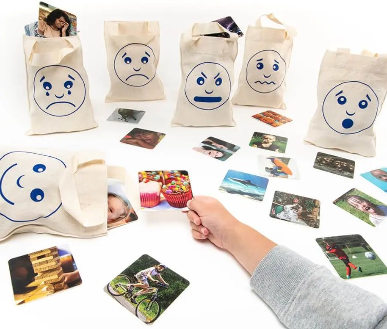 borse con facce rappresentanti le emozioni: tristezza, paura, felicità, stupore