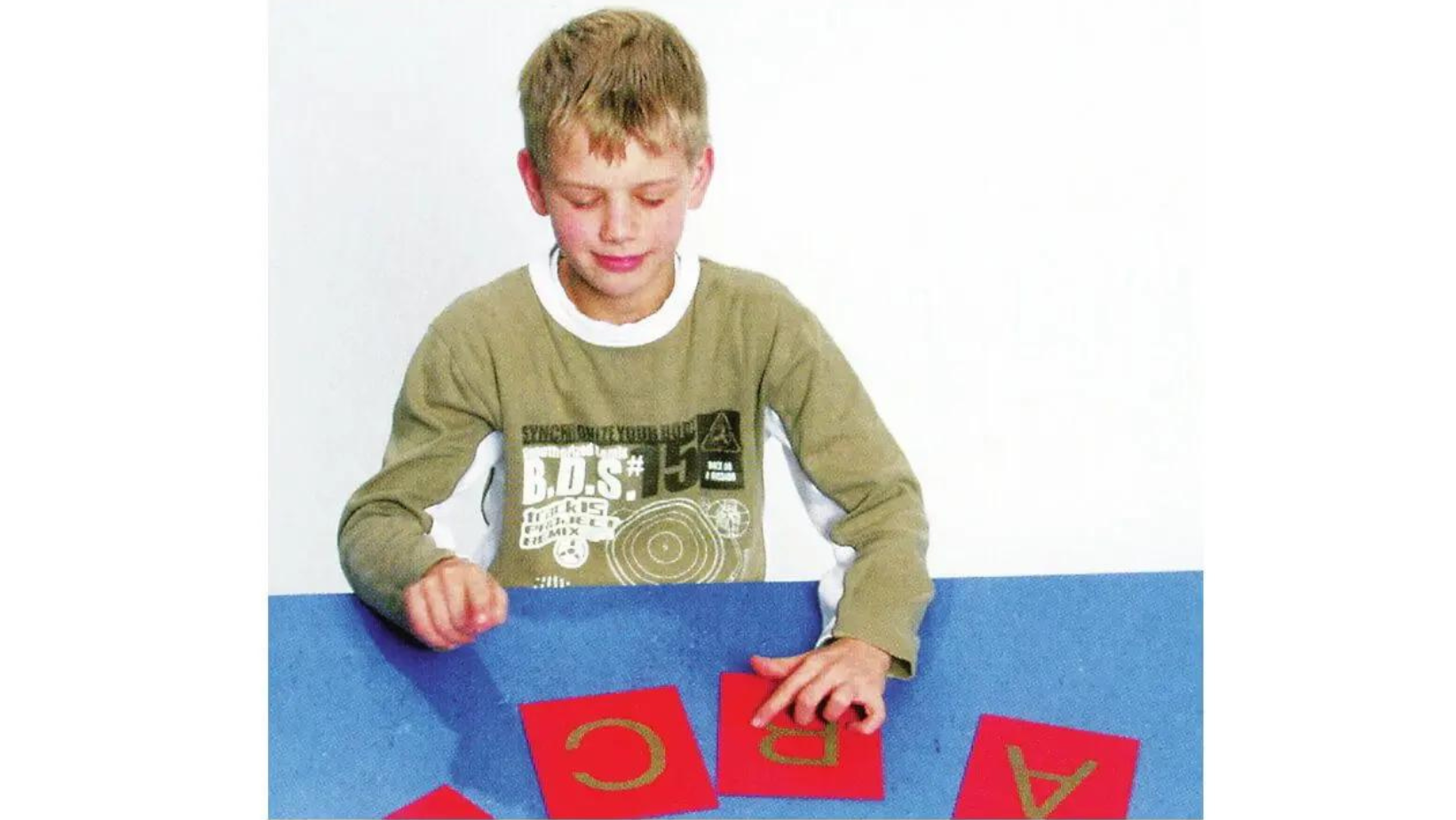 Bimbo che gioca con delle carte con lettere in rilievo 