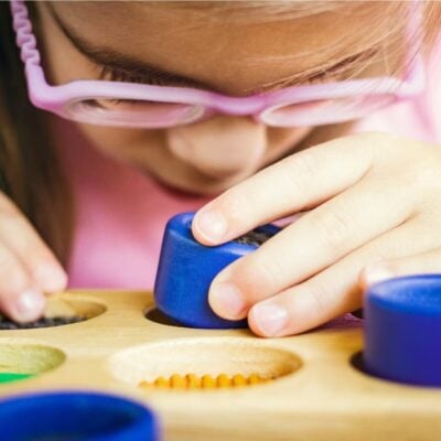 neuropsicomotricità infantile: bambina che utilizza dei giochi materiali colorati