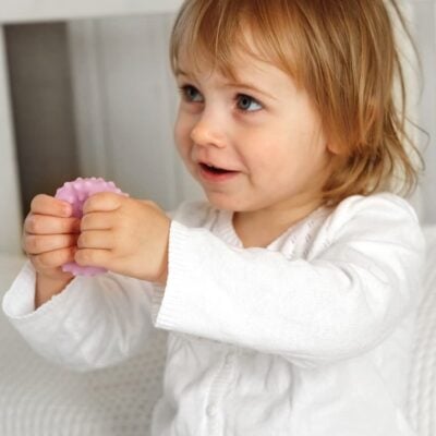 Bambina che gioca che una pallina sensoriale rosa