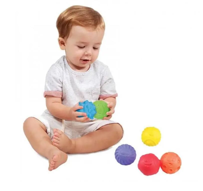 bambino che gioca con le palline sensoriali colorate (viola, rosso, arancione, azzurro, verde)
