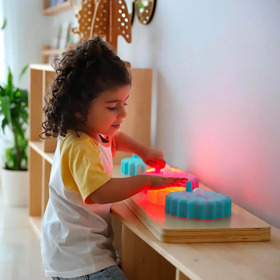 bambina che gioca con pannello ingranaggi luminosi