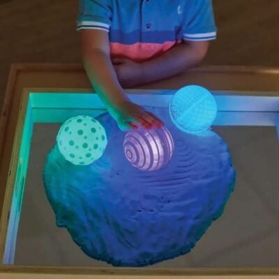 bambino/a che gioca con palline luminose sensoriali
