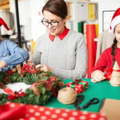 insegnante con due allievi a lato. Creano lavori di natale