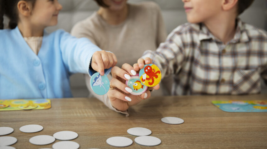 madre con bambini che giocano a giochi da tavolo educativi