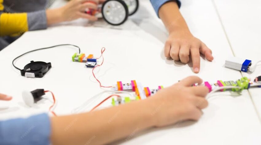 giochi stem: mani di bambini che giocano e impagano sul tavolo.