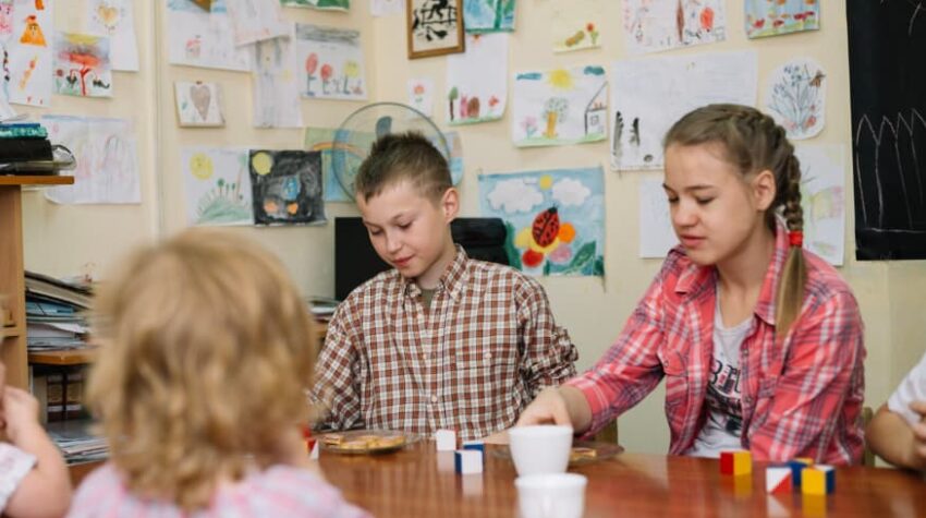 gestione della classe con il gioco, bambini attorno ad un tavolo che giocano