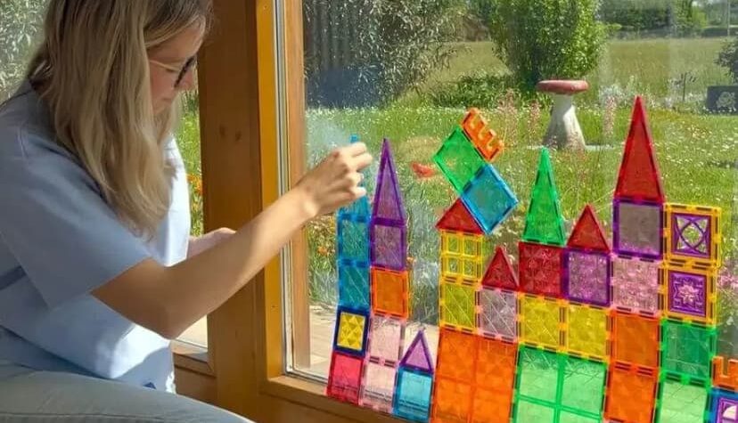 costruzioni magnetiche appese al vetro da una ragazza